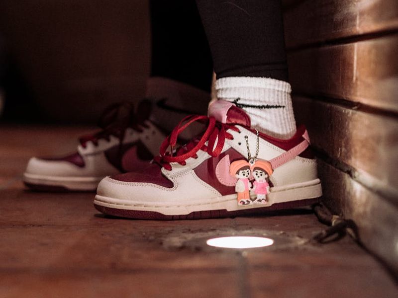 Close-up of a person's athletic shoes on a wooden floor.